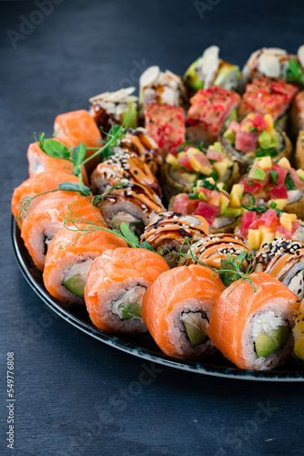 Set of japanese sushi rolls with tuna, sea bass, salmon, cucumber, avocado, cream cheese, mango, sesame, almond and green pea.