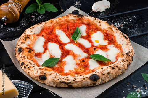 Italian cuisine pizza with mozzarella, tomato sauce, spinach on a thick dough.