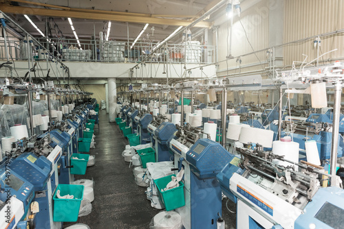 Interior of garment factory shop. Textile workshop with sewing machines, industry concept