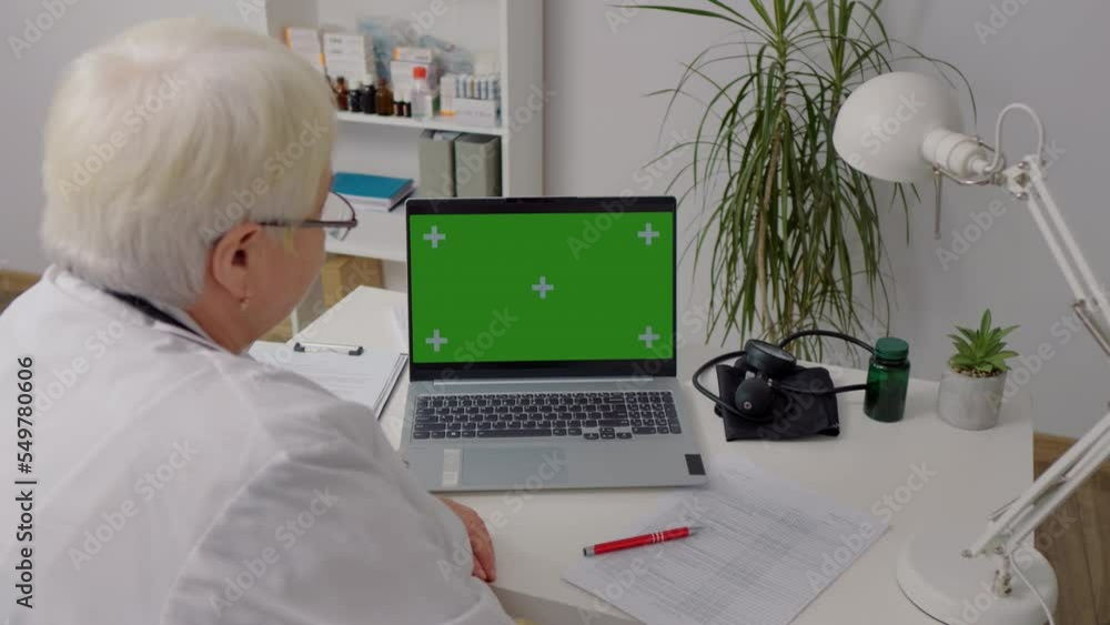 Gadgets used in healthcare by female doctor watching green screen