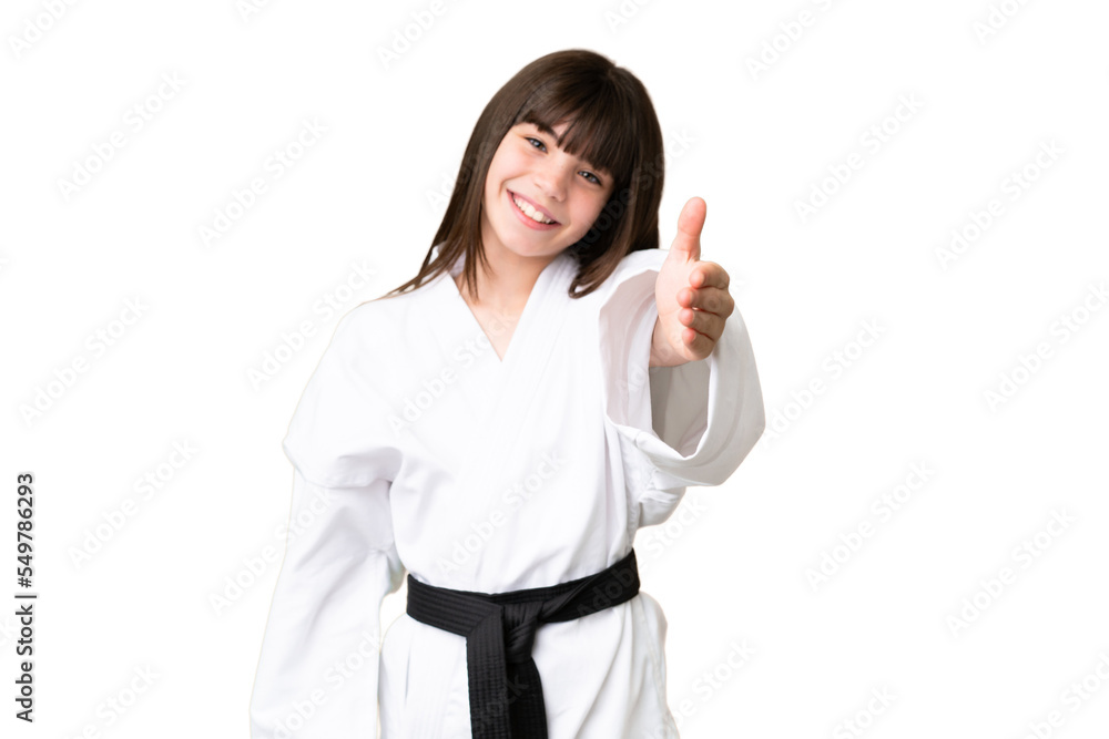 Little Caucasian girl doing karate over isolated background shaking hands for closing a good deal Little Caucasian girl doing karate over isolated background shaking hands for closing a good deal