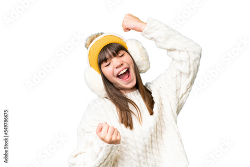Little caucasian girl wearing winter muffs over isolated background celebrating a victory