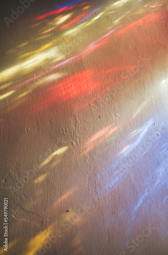 Colourful rays of light on an old plaster wall