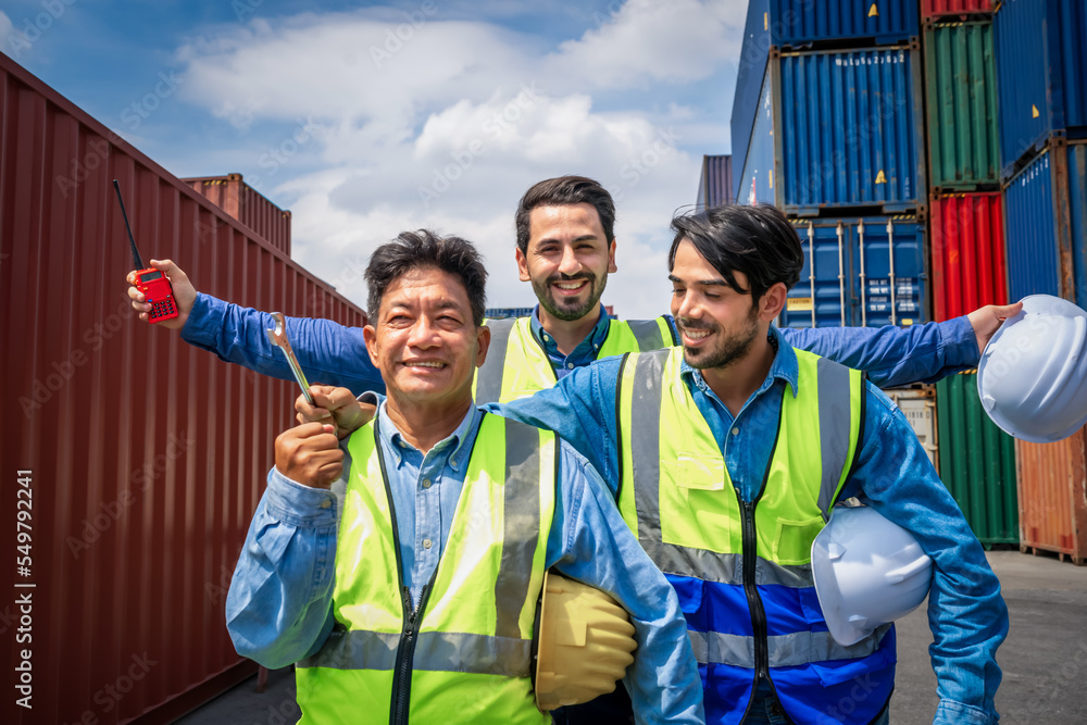 Portrait of Engineer or foreman team raising arms celebrate with cargo container background at sunset. Logistics global import or export shipping industrial concept. Portrait of Engineer or foreman team raising arms celebrate with cargo container background at sunset. Logistics global import or export shipping industrial concept.