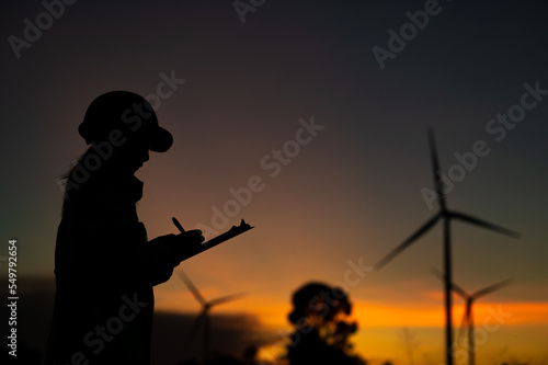 Asian Man engineers working and holding the report at wind turbine farm Power Generator Station on mountain,Thailand people,Technician man at site of work
