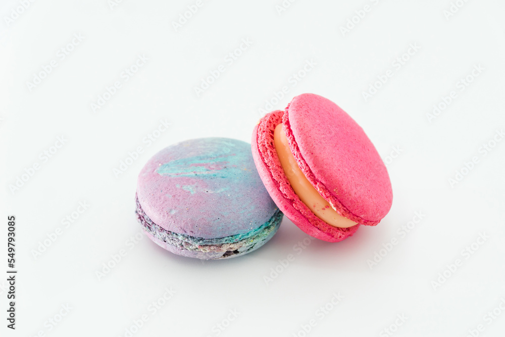 Sweet colorful macarons isolated on white background. Tasty colourful macaroons. Two multi-colored blue and pink macaroons. French pastry made from egg whites. Sweet colorful macarons isolated on white background. Tasty colourful macaroons. Two multi-colored blue and pink macaroons. French pastry made from egg whites.