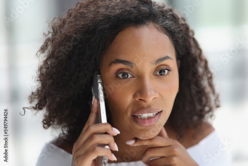 Portrait of a young attractive African American woman talking on the phone