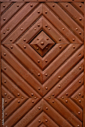 part of the decor and the material from which it is made; old forged wooden door with a symmetrical pattern 