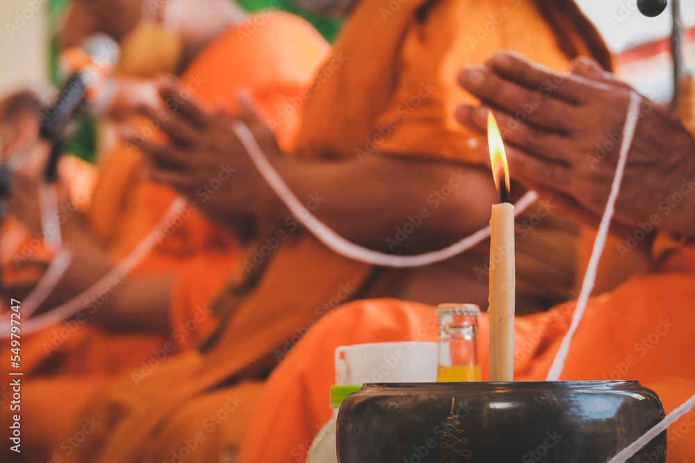 Buddhist monks chant a ritual with candles as the main element of the