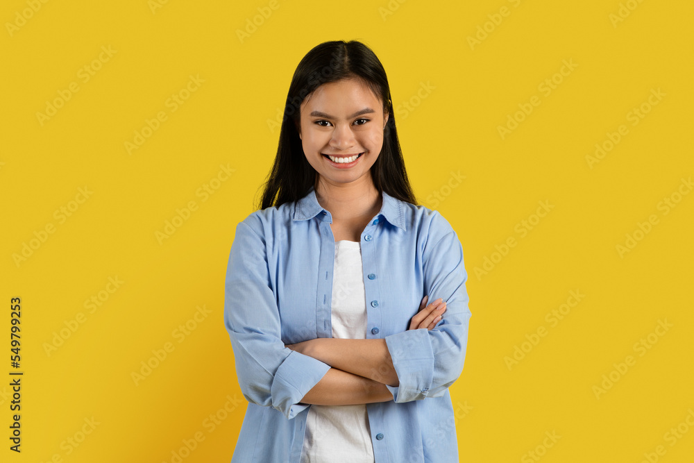 New style and success. Happy confident millennial korean lady student in casual with crossed arms look at camera New style and success. Happy confident millennial korean lady student in casual with crossed arms look at camera