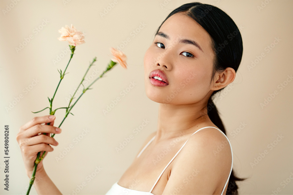 Asian Woman Posing In Studio. Woman With Flower. Body Care. Asian Woman Posing In Studio. Woman With Flower. Body Care.