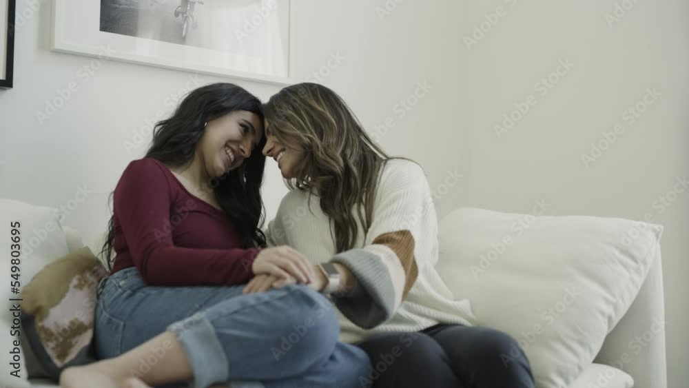 Zoom in to slow motion of smiling mother and daughter talking on sofa / Lehi, Utah, United States Zoom in to slow motion of smiling mother and daughter talking on sofa / Lehi, Utah, United States