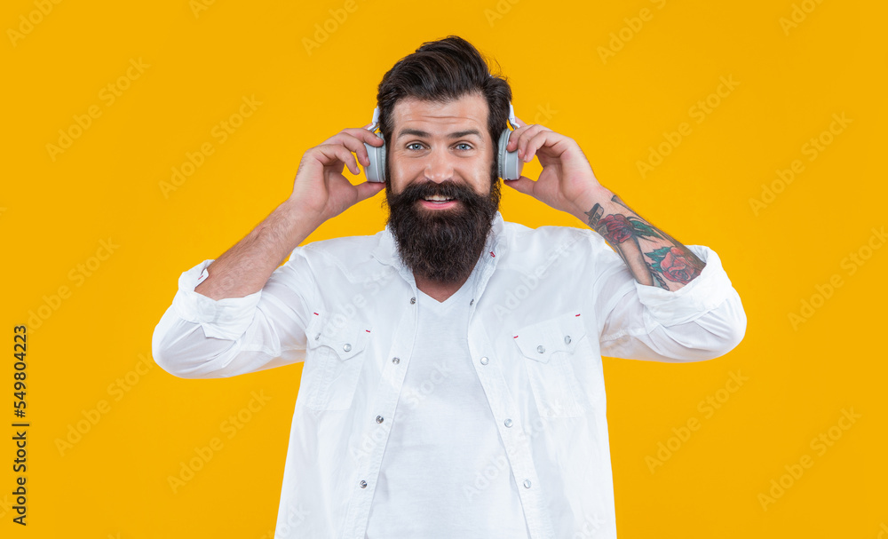studio shot of cheerful hipster holding headphones to listen ebook. man hipster listen ebook studio shot of cheerful hipster holding headphones to listen ebook. man hipster listen ebook