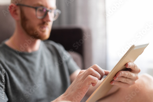 Man choose something on a tablet with his point finger. Man using a tablet.