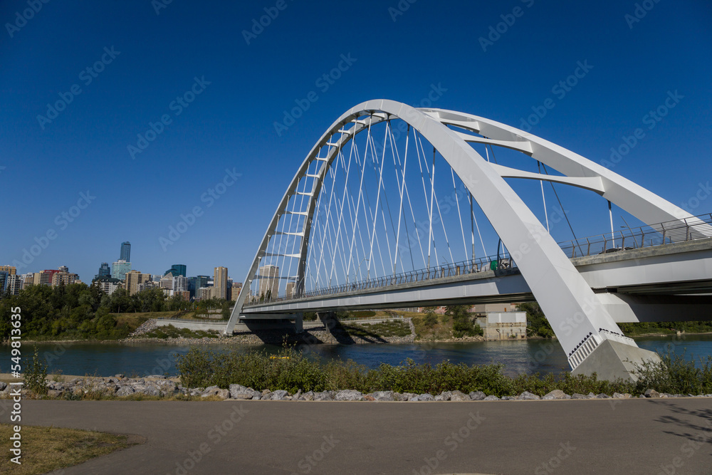 Naklejka premium Modern arc bridge over the river, day traffic, summer time. modern architecture, panorama of the city Edmonton
