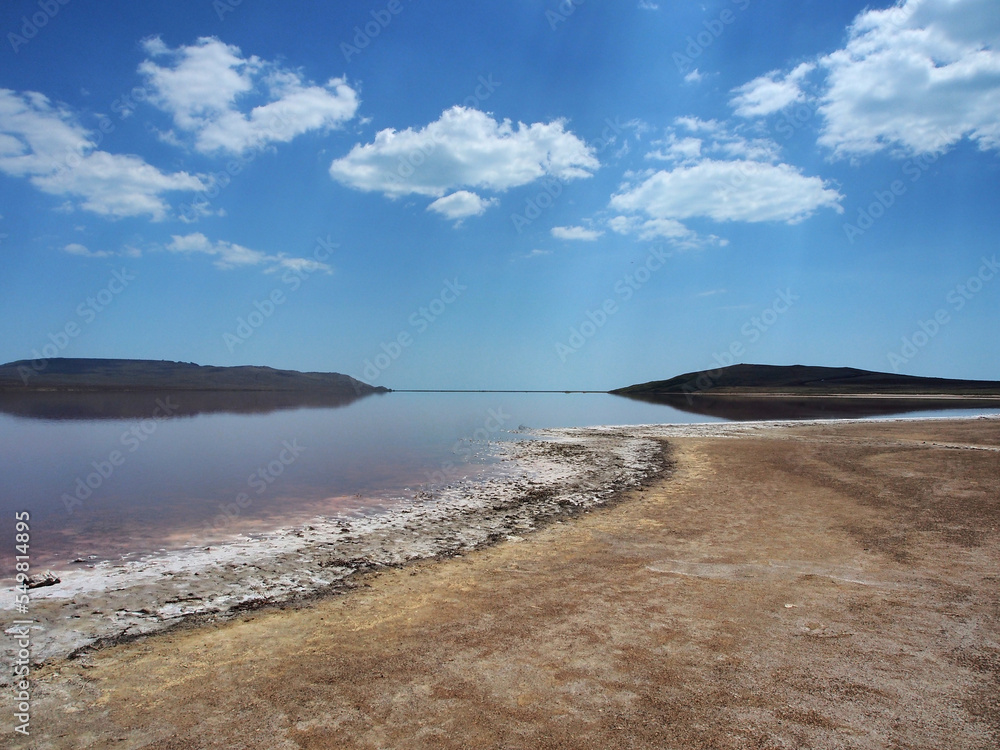 Landscape, a salt lake illuminated by the sun against a clear, cloudless sky. Wildlife, the concept of tourism, recreation and travel.