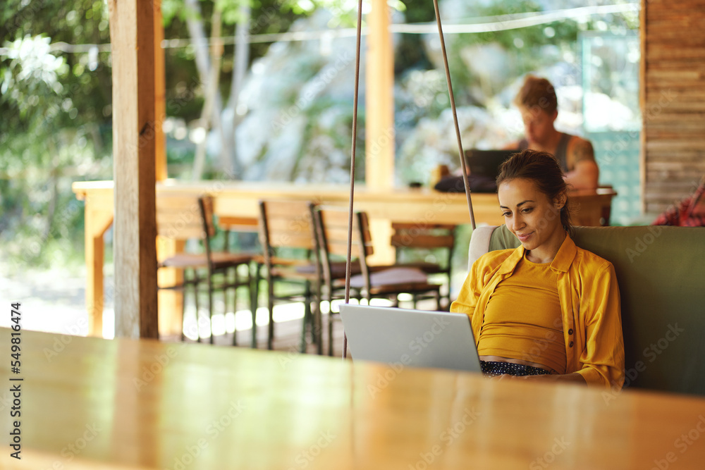 Pretty woman checking her mail on portable laptop in summer cafe shop or coworking hub. Summer vacations and sometimes working remotely Pretty woman checking her mail on portable laptop in summer cafe shop or coworking hub. Summer vacations and sometimes working remotely