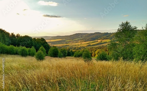 View of the Jeleniogorska Valley. Sunset in the mountains. Yellow grasses and green trees against the background of the mountains