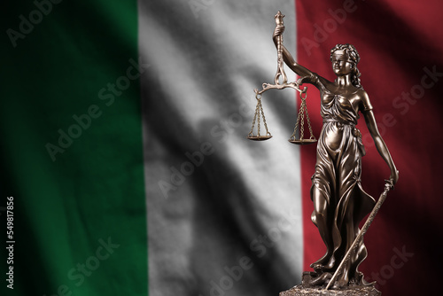 Italy flag with statue of lady justice and judicial scales in dark room. Concept of judgement and punishment photo