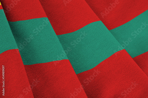 Transnistria flag with big folds waving close up under the studio light indoors. The official symbols and colors in banner