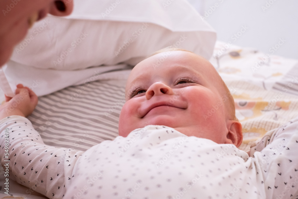Cute little baby girl lying on the bed waling up in the morning