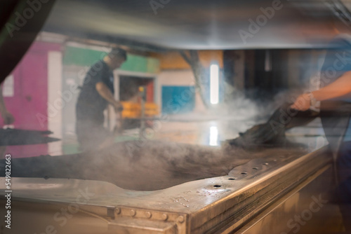 Картината върху платно Steam from the skin when leveling and processing leather products at the factory in the workshop using special equipment