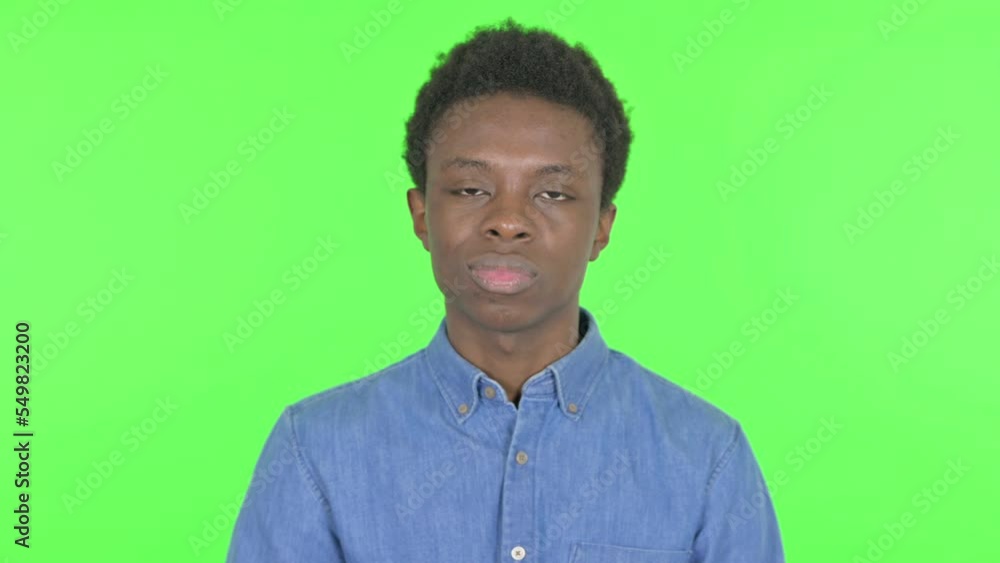 Upset Young African Man Showing Middle Finger on Green Background Upset Young African Man Showing Middle Finger on Green Background