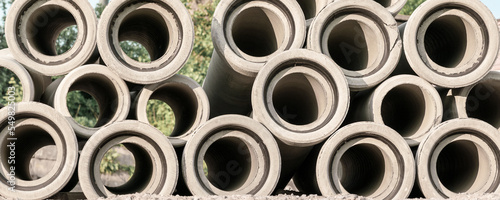 Concrete industrial pipes heap stack on construction site for sewage maintenance