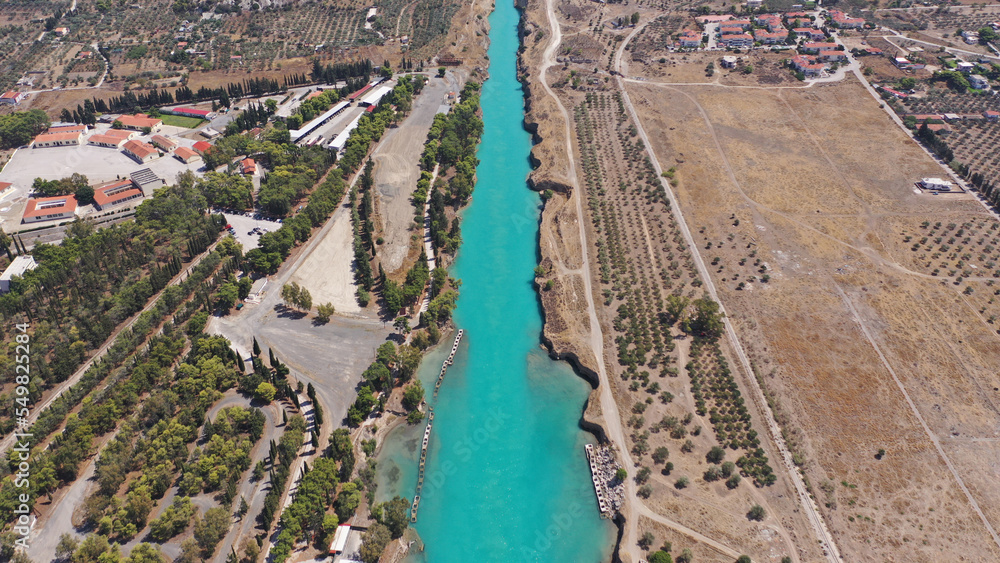 Fototapeta premium Aerial drone photo of yacht crossing narrow Corinth canal of Isthmus from West submersible bridge and narrow opening of Corinthian gulf to Saronic gulf, Loutraki, Greece