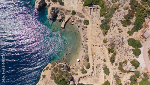 Aerial drone photo of famous archaeological site of Heraion in Cape Melagavi featuring a small beach next to iconic lake Vouliagmeni and lighthouse, Corinthian bay, Perachora, Loutraki, Greece photo