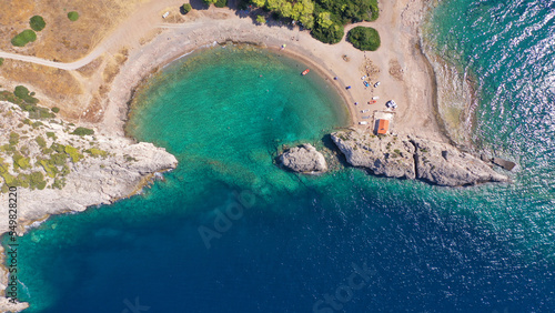 Aerial drone top down photo of scenic half moon shaped crystal clear sea beach of Milokopi near famous lake Vouiagmeni, Loutraki, Perachora, Greece photo