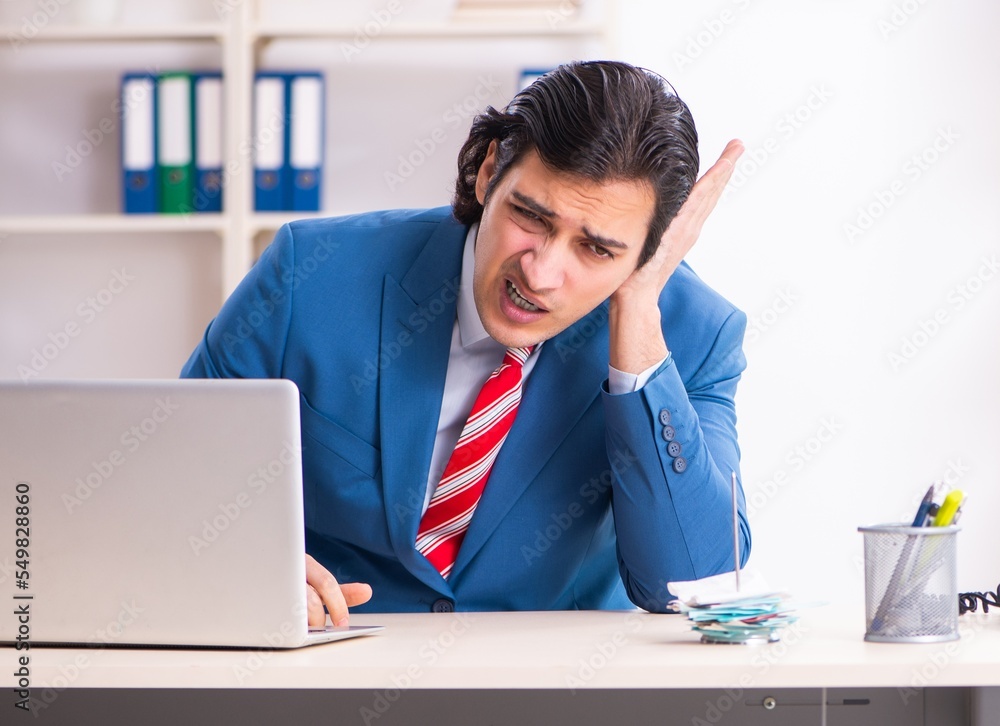 Young male employee suffering in the office Young male employee suffering in the office
