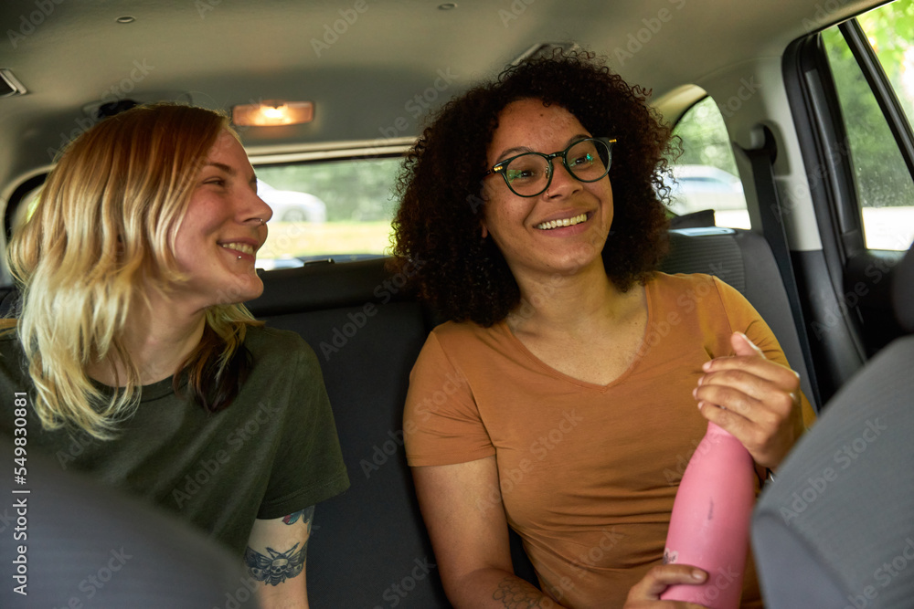 LGTBQ+ couple smiling in a suv on a road trip going camping LGTBQ+ couple smiling in a suv on a road trip going camping