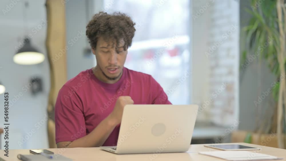 African Man Coughing while Working on Laptop African Man Coughing while Working on Laptop