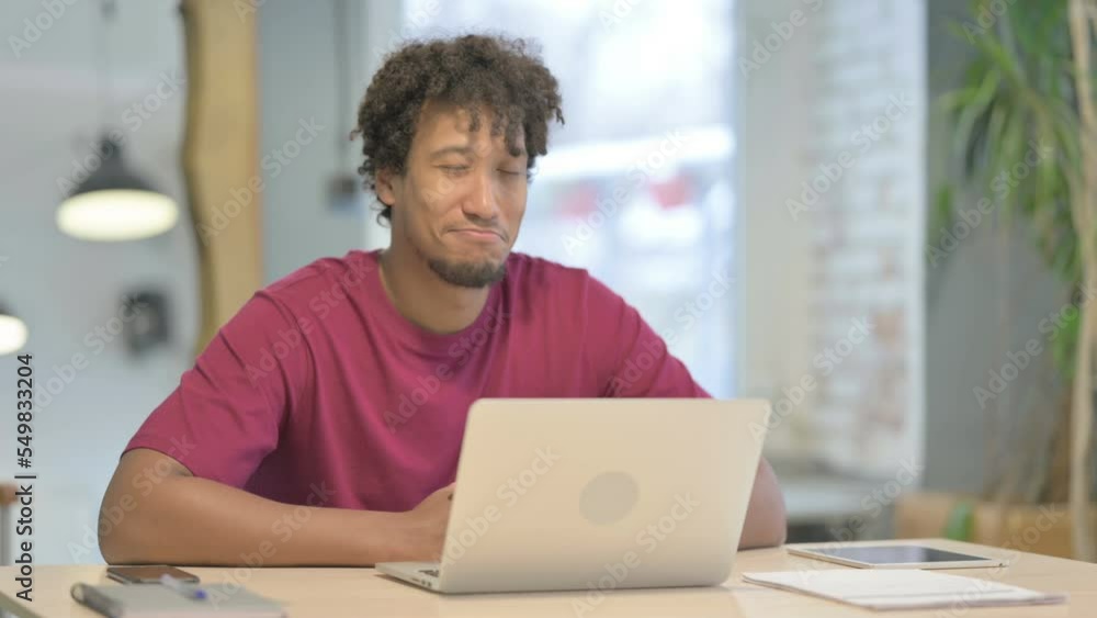 African Man Shaking Head in Acceptance While Working on Laptop African Man Shaking Head in Acceptance While Working on Laptop
