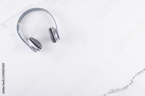White headphones top view on white marble background with copy space, listening concept flat lay