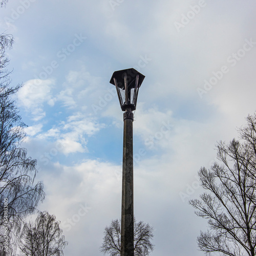 Broken old street lamp with cloudy sky on background