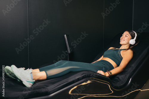 An Asian girl lying on an electric water table, chromotherapy. The girl is resting lying down.