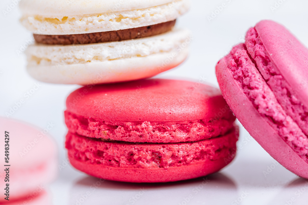 Close up of Macaroons in different colours on bright white background with subtle reflection on marble tray. Popular merengue dessert with filling inside. Close up of Macaroons in different colours on bright white background with subtle reflection on marble tray. Popular merengue dessert with filling inside.