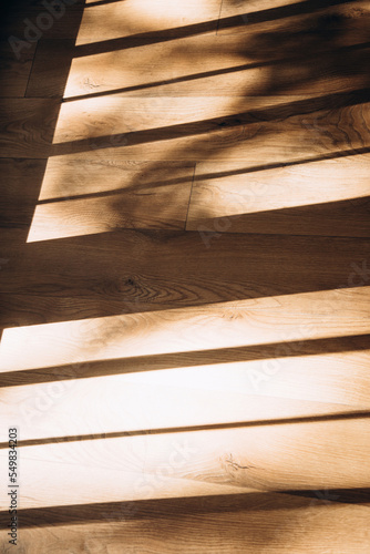 Shadows near the window from daylight in the form of stripes on the wooden floor. Abstract background for design