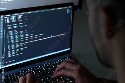 Male writing code on laptop screen. Software programmer and web developer.