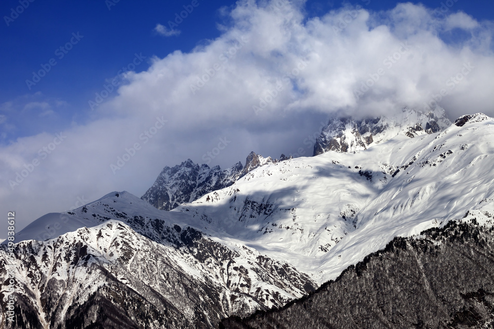 Obraz premium Snow mountains in clouds in winter sun day
