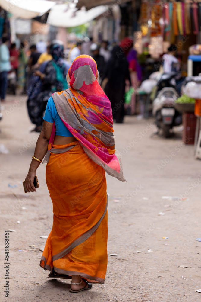 Mujer hindú vestida con sari caminando por la calle Mujer hindú vestida con sari caminando por la calle