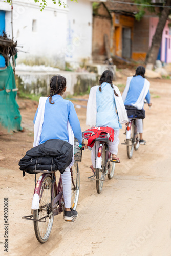 Young girls going to school by bicycle in India
