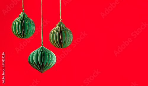 Origami green paper Christmas ornament on red background . Chinese new year concept . Banner.