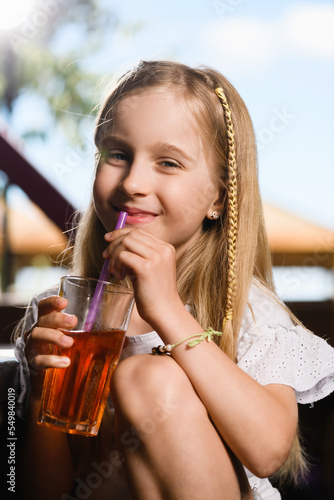 Little girl with glass of berry drink