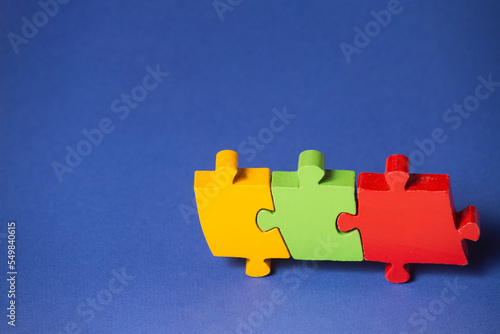 concept of group support. help to a third party. 3 puzzle pieces linked together. selective focus. copying space.