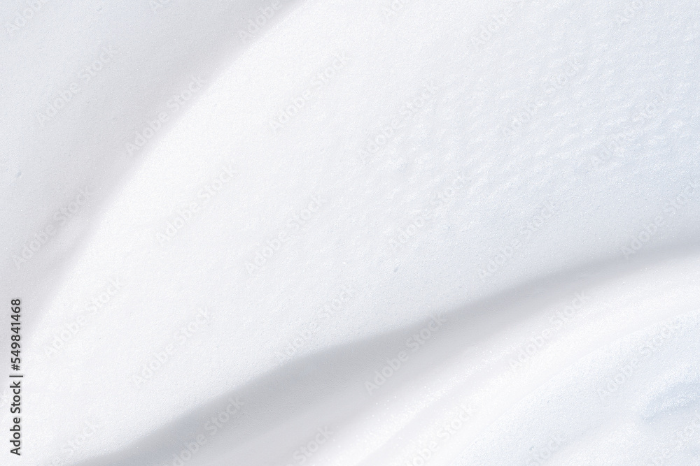 Smooth smudge of white shaving foam. White foamy texture closeup. Background of white foamed cosmetic product.
