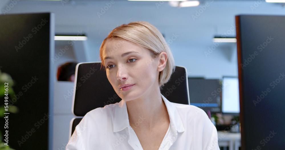 Close up of beautiful Caucasian woman sitting at computer screen and typing on keyboard. Customer support online. Female working at office. IT worker. Workday at coworking center. Freelancer.