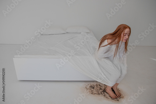 Фотография Depressed woman sitting on the bed